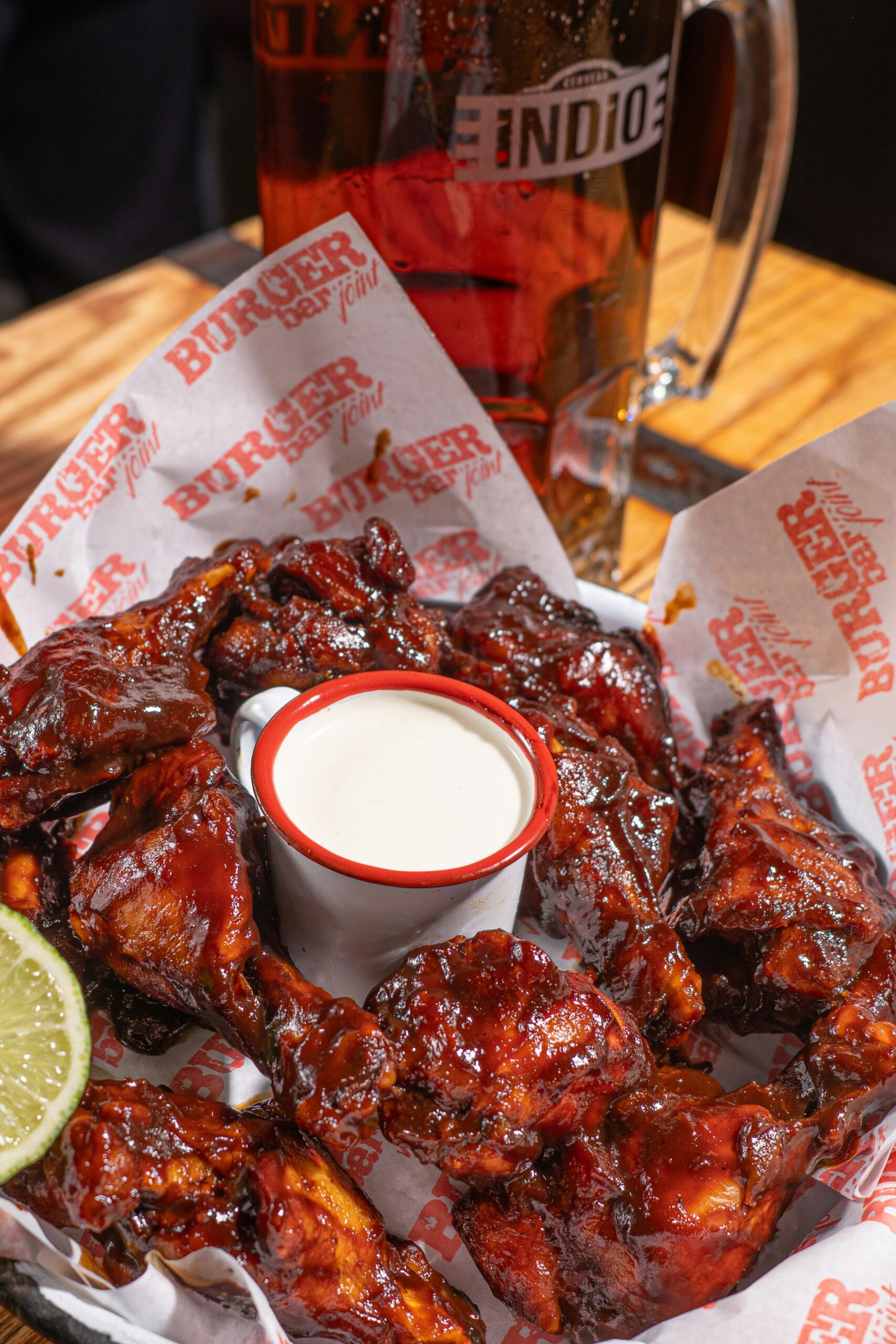 Tempting BBQ chicken wings served with creamy dip and refreshing beer.